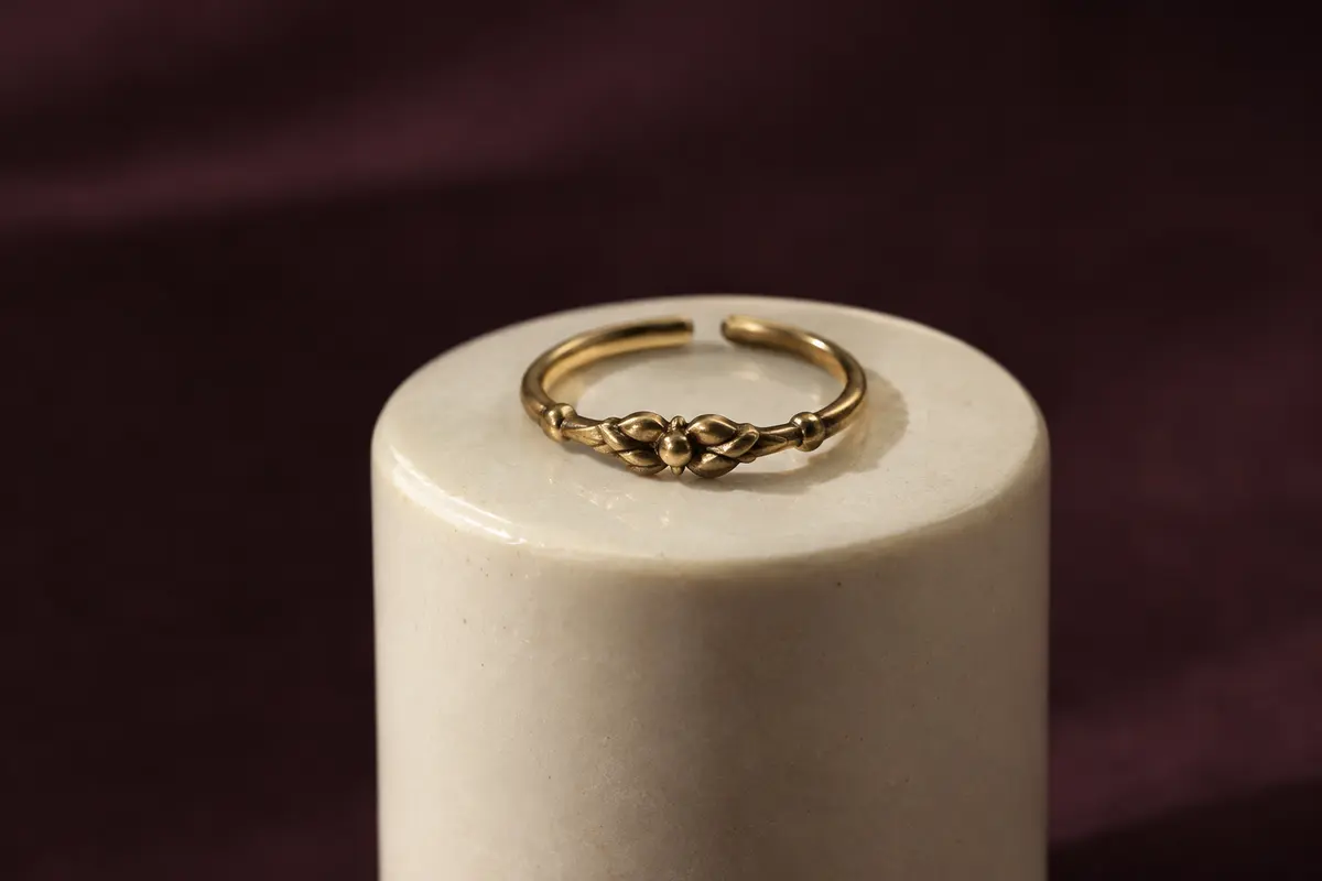 Petite bague de phalange présentée sur un support en céramique ivoire