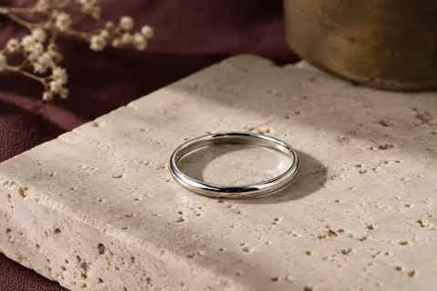 Alliance fine en argent sterling 925 au profil en D, posée sur du travertin clair